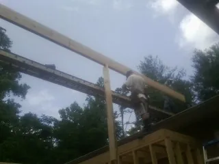 Carpenter setting a ridge beam over a new addition frame — Ice Dam Removal by Roofing Brothers in Maplewood