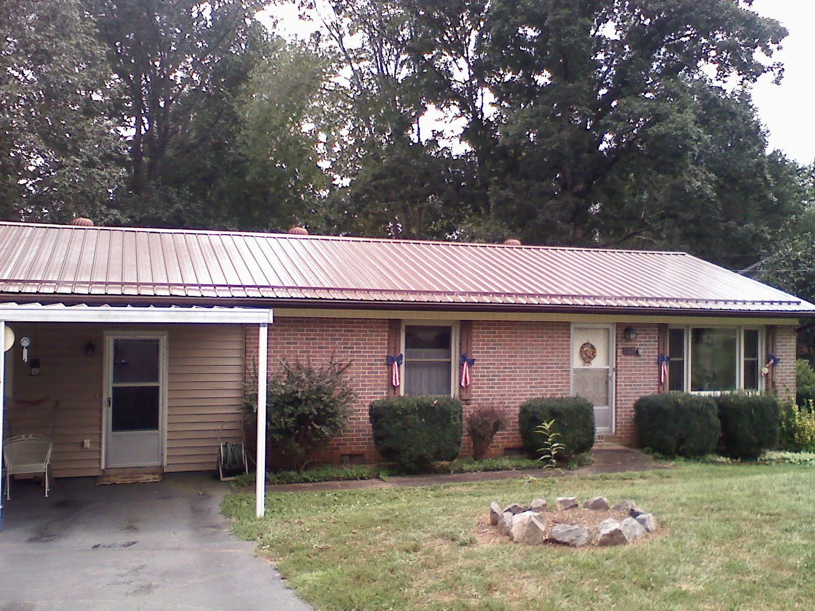 Bronze metal roof and carport on a brick ranch home — Roof Repair work by our crew in Maplewood